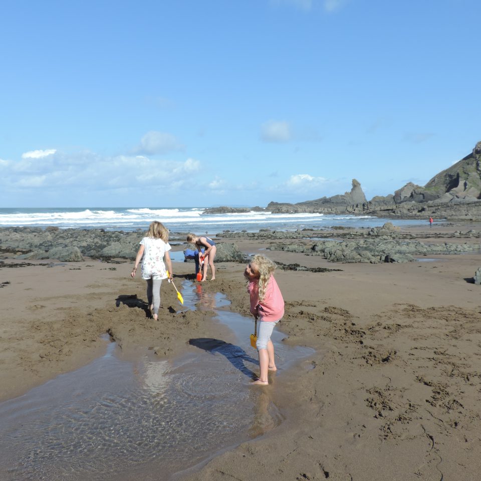 Family playing in sand on Hartland Quay beach