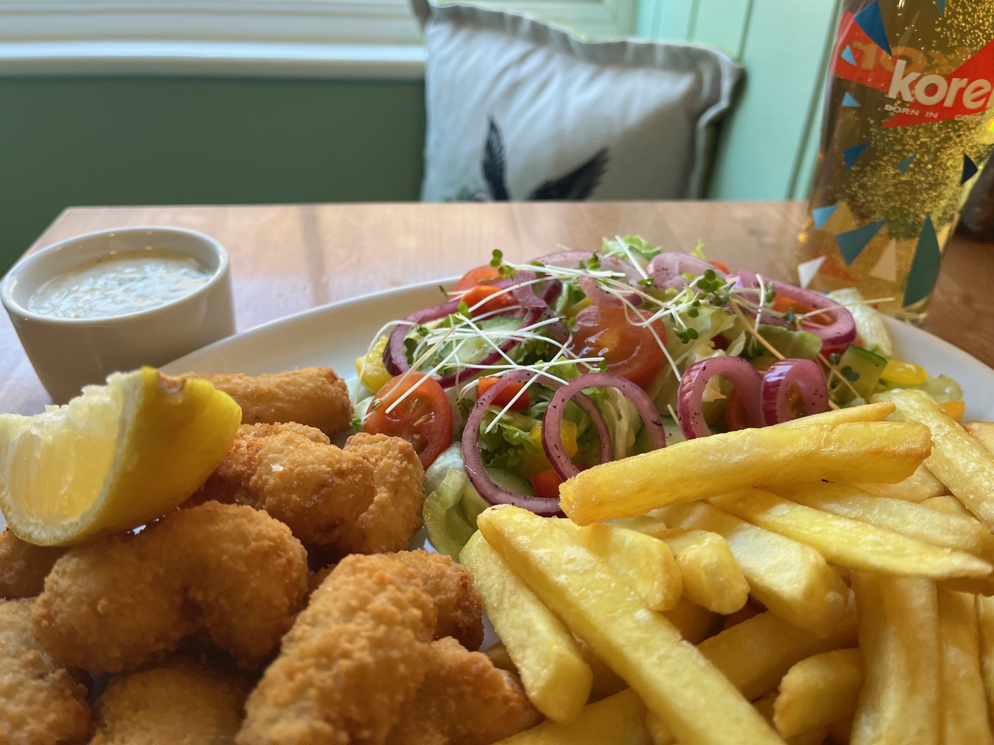 Plate of scampi and chips with pint of lager in restaurant of Hartland Quay